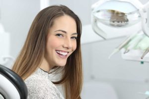 young woman in dentist chair smiling